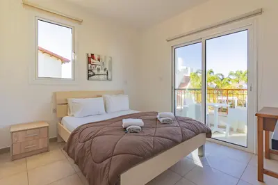 a bedroom with a large bed and a balcony at Villa Rosita in Paralimni