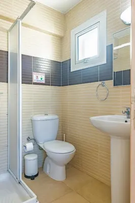 a bathroom with a toilet and a sink at Villa Rosita in Paralimni