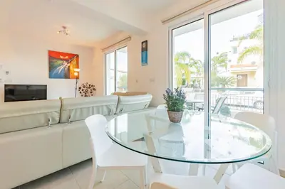 a living room with a white couch and a glass table at Villa Rosita in Paralimni