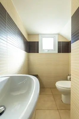 a bathroom with a tub and a toilet and a window at Villa Rosita in Paralimni