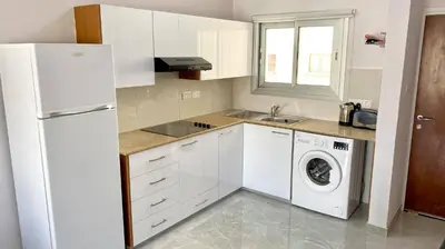 a kitchen with a white refrigerator and a washing machine at Napa Court 2 in Ayia Napa