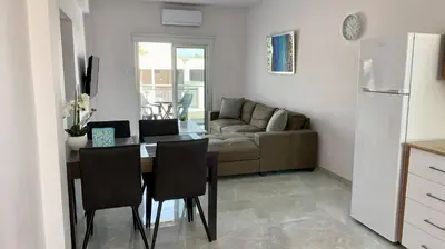 a kitchen and living room with a table and a couch at Napa Court 2 in Ayia Napa