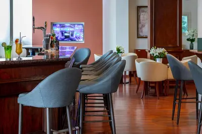 a bar with blue chairs and a counter at Kapetanios Limassol Hotel in Limassol