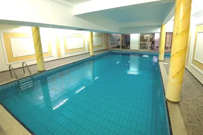 a large swimming pool in a large building at Kapetanios Limassol Hotel in Limassol