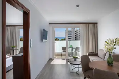 a living room with a couch and a table at Kapetanios Limassol Hotel in Limassol