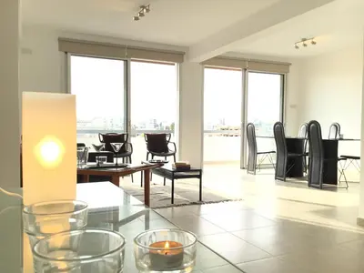 a living room with tables and chairs and windows at RESIDENCE ONE in Limassol