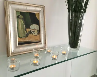 a glass shelf with candles and a vase with a painting at RESIDENCE ONE in Limassol