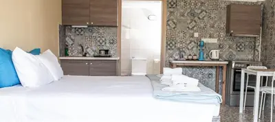 a bedroom with a large white bed and a kitchen at Lucky 2 in Paralimni