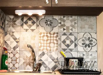 a kitchen with a sink and a tile wall at Lucky 2 in Paralimni
