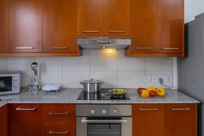 a kitchen with wooden cabinets and a stove top oven at Faros BeachFront Villa in Pervolia