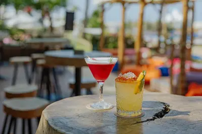 a cocktail and a drink on a wooden table at Golden Coast Beach Hotel in Protaras