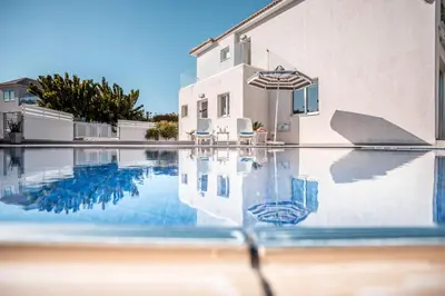 a swimming pool in front of a house at Villa Hibiscus in Protaras