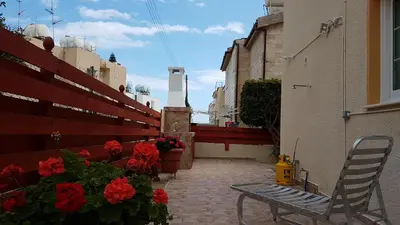 a bench sitting on a patio next to flowers at Philippou Beach Villas & Apartments in Larnaka