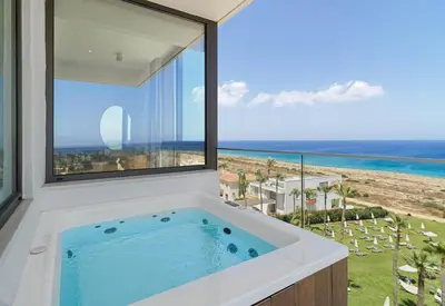 a bath tub with a view of the ocean at Leonardo Crystal Cove Hotel & Spa – Adults only in Protaras