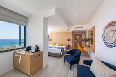 a hotel room with a bed and a view of the ocean at Leonardo Crystal Cove Hotel & Spa – Adults only in Protaras