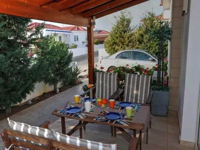 a wooden table and chairs on a patio at Villa Anastasia in Ayia Napa