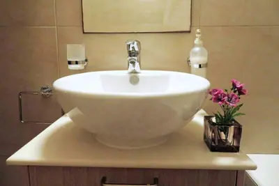 a bathroom with a white sink with a vase of flowers at Villa Anastasia in Ayia Napa