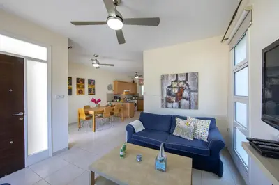 a living room with a blue couch and a table at Protaras Villa Marilia in Protaras