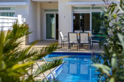 a patio with a table and chairs next to a pool at Protaras Villa Marilia in Protaras