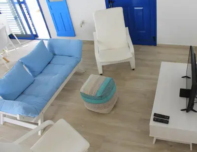 a living room with a blue couch and a chair at Villa St. Nicolas 8 - Protaras in Protaras