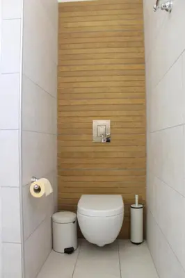 a bathroom with a toilet and a wooden wall at Villa St. Nicolas 8 - Protaras in Protaras