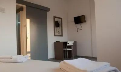 a bedroom with a bed and a tv on the wall at St. George Rent Rooms in Larnaka