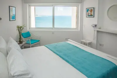 a white bedroom with a large bed and a window at Front-Row - Skyline Retreat - Pool Access in Larnaka