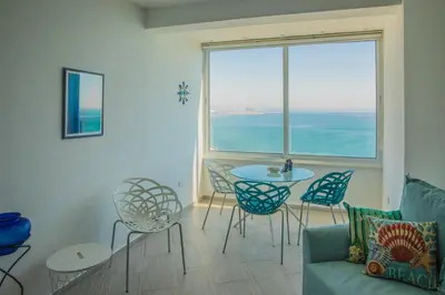 a living room with a table and chairs and a large window at Front-Row - Skyline Retreat - Pool Access in Larnaka