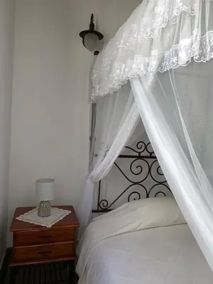 a bedroom with a white canopy bed with a wooden table at Lofou Traditional House in Lofou