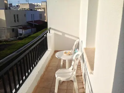 a white table and a chair on a balcony at Spacious 1 Bedroom Apartment in Kapparis Area in Paralimni