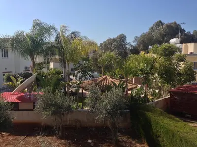 a garden with palm trees and a building at Spacious 1 Bedroom Apartment in Kapparis Area in Paralimni