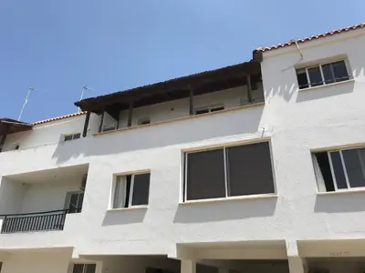 a white building with windows on the side at Spacious 1 Bedroom Apartment in Kapparis Area in Paralimni