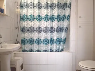 a bathroom with a shower curtain and a toilet at Spacious 1 Bedroom Apartment in Kapparis Area in Paralimni