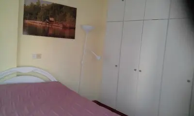 a bedroom with a bed and a lamp at LIRA in Larnaka