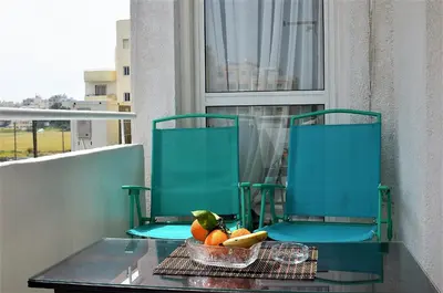 a bowl of fruit on a table with two chairs at LIRA in Larnaka