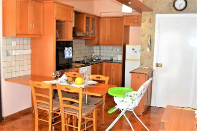 a kitchen with a table and chairs in a kitchen at LIRA in Larnaka