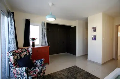 a living room with a chair and a window at Villa Carmel in Ayia Napa