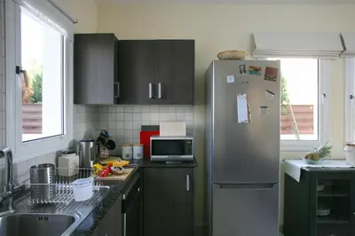 a kitchen with a refrigerator and a sink at Villa Carmel in Ayia Napa