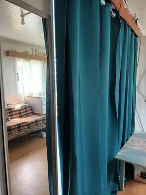 a room with blue curtains and a mirror at Mazotos beach house in Mazotos