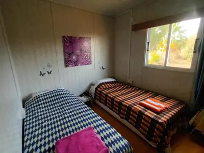 two beds in a small room with a window at Mazotos beach house in Mazotos