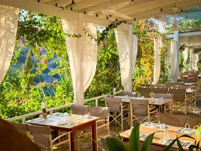 a restaurant with tables and chairs and flowers at Cyprus Villages - Hotel & Restaurant - Central Location - Bed & Breakfast With Access To Pool And Stunning Views in Tochni