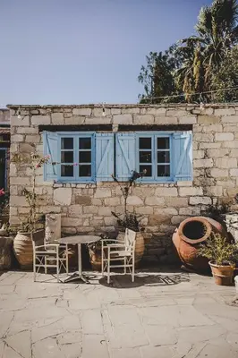 a table and chairs in front of a stone building at Cyprus Villages - Hotel & Restaurant - Central Location - Bed & Breakfast With Access To Pool And Stunning Views in Tochni