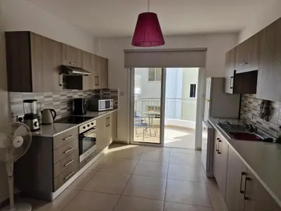 a kitchen with a pink light hanging over it at Oceania Bay Village in Pyla