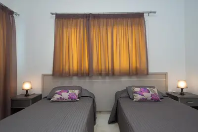 a bedroom with two beds and two lamps at Makronissos Beach Villas in Ayia Napa