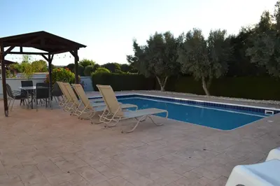 a group of chairs sitting next to a swimming pool at Makronissos Beach Villas in Ayia Napa
