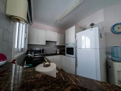 a kitchen with white cabinets and a white refrigerator at Blue Bay Beach House in Larnaka