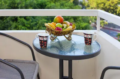 a bowl of fruit on a table with two cups at Poseidon Boutique Apartment 2 in Limassol