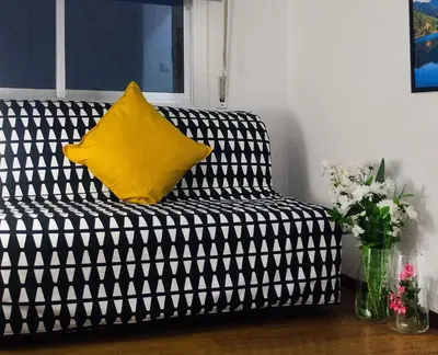 a black and white couch with a yellow pillow on it at Poseidon Boutique Apartment 2 in Limassol