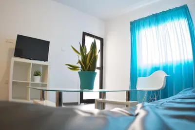 a bedroom with a glass table and a plant at Margarita Napa Apartments in Ayia Napa
