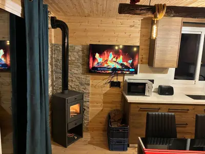 a living room with a stove and a tv on a wall at SOFROS VALLEY HILLS CHALET in Ayios Mamas